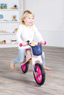 Mädchen fährt mit rosafarbenen Laufrad